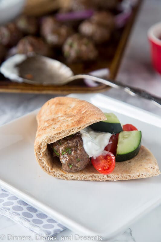 pita with eatballs and tzatzki sauce and cucumbers on a plate