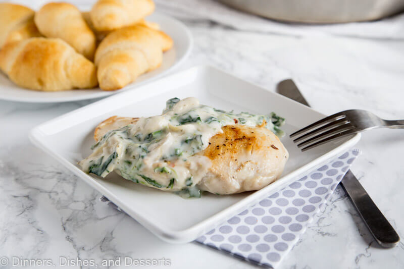 A plate of food with chicken with spinach artichoke sauce