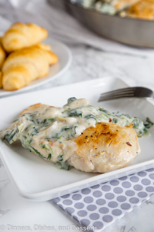 A plate of food on a table, with chicken with spinach artichoke sauce
