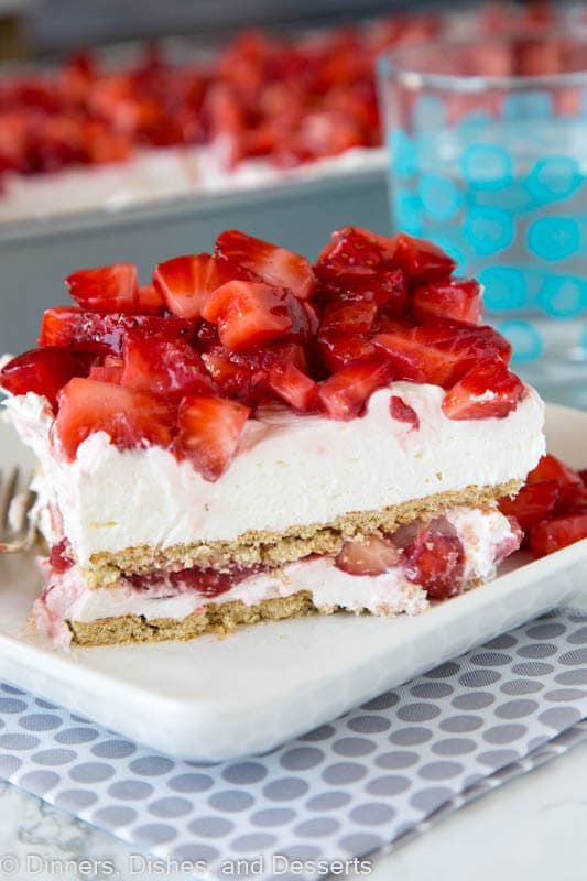 strawberry cheesecake lasagna with fresh strawberries on a plate with a fork