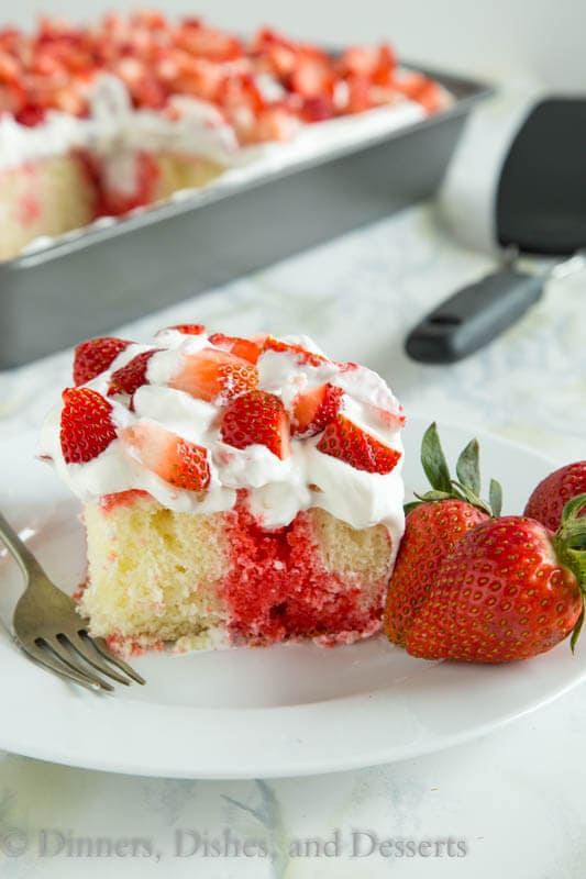 Poke cake with strawberry jello and fresh shipped cream in white pate