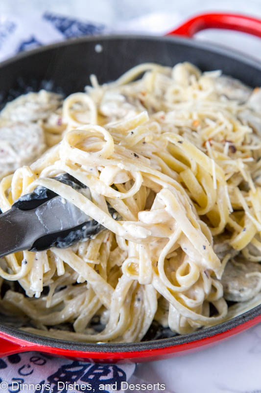 A skillet of pasta with sauce and cheese, with chicken sausage and Fettuccine Alfredo