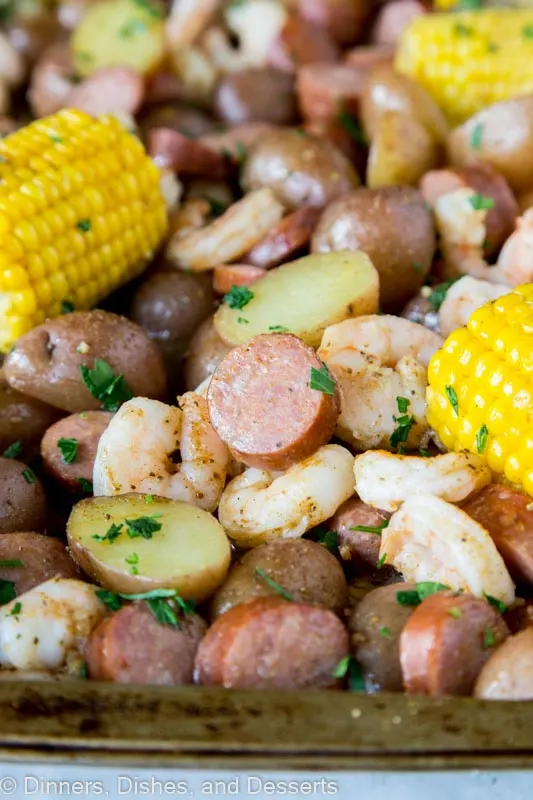 A pile of sheet pan with corn, shrimp, sausage, potatoes