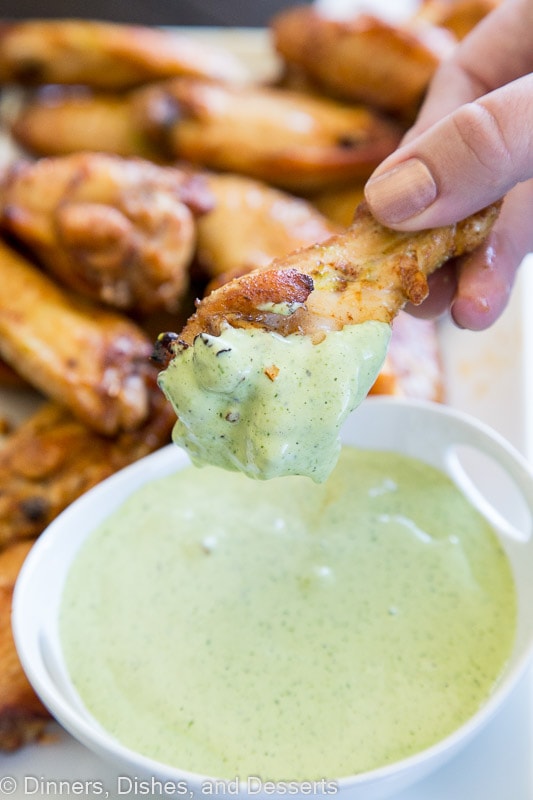 A close up of food, with Chicken wing and green sauce