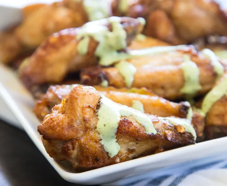 Baked Chicken Wings with Creamy Green Sauce - get the taste of Peru with these super easy chicken wing. Tons of seasoning and a creamy cilantro lime sauce for dipping!