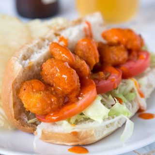 A close up of food on a plate, with Shrimp on a bun