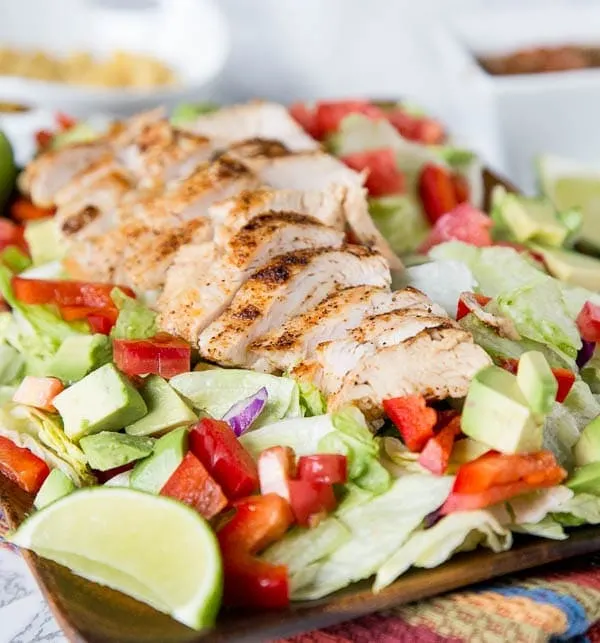 Chicken Fajita Salad - a hearty salad topped with grilled chicken, peppers, onion, avocados, and a salsa vinaigrette dressing. Definitely not your average salad!