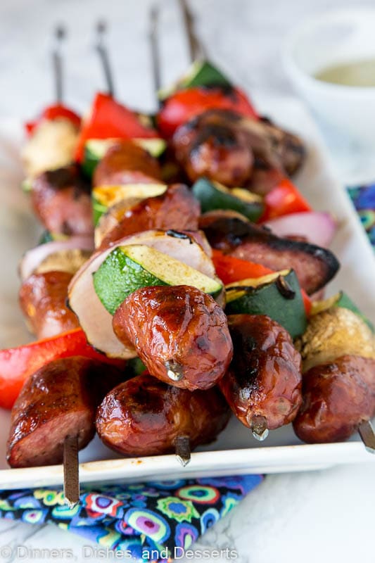 grilled sausge and veggie kebabs on a plate