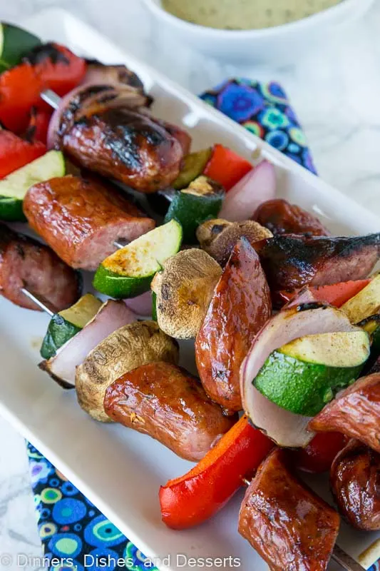 grilled sausage and veggie kebabs on a plate