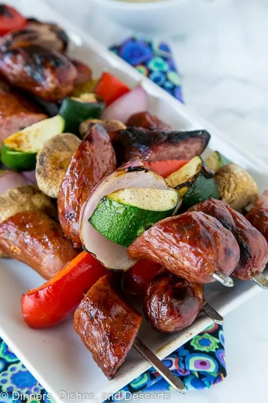 grilled sausge and veggie kebabs on a plate