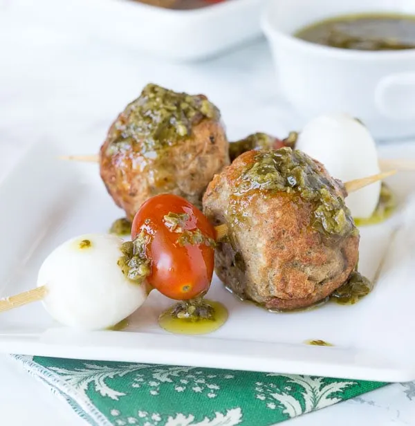 Italian Meatball Caprese Skewers - Make summer entertaining easy with these little skewers. An Italian style meatball, fresh Mozzarella cheese, and tomato, topped with a basil vinaigrette!