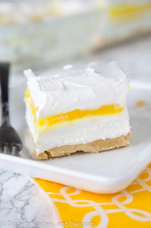 A piece of cake on a plate, with lemon Cream and Whipped cream