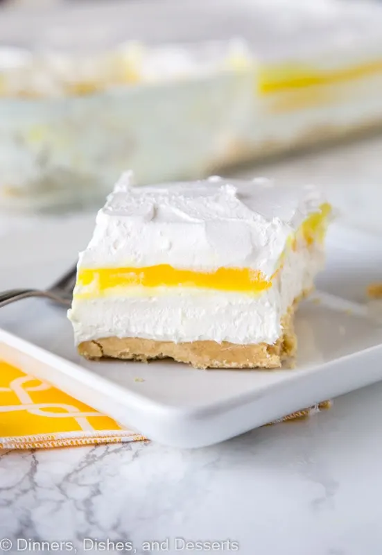 A piece of cake on a plate, with Lemon and Cream layers