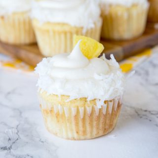 A close up of A close up pineapple cupcakes with coconut and pineapple piece