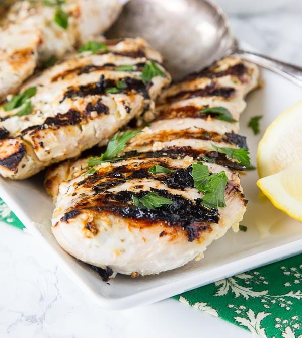 grilled chicken on a plate with lemon slices
