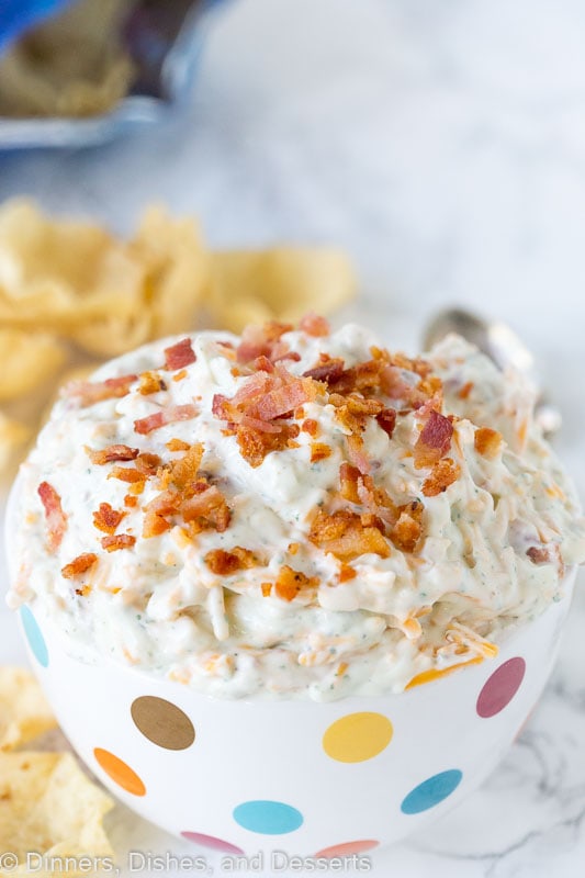 A close up of ranch dip topped with bacon pieces