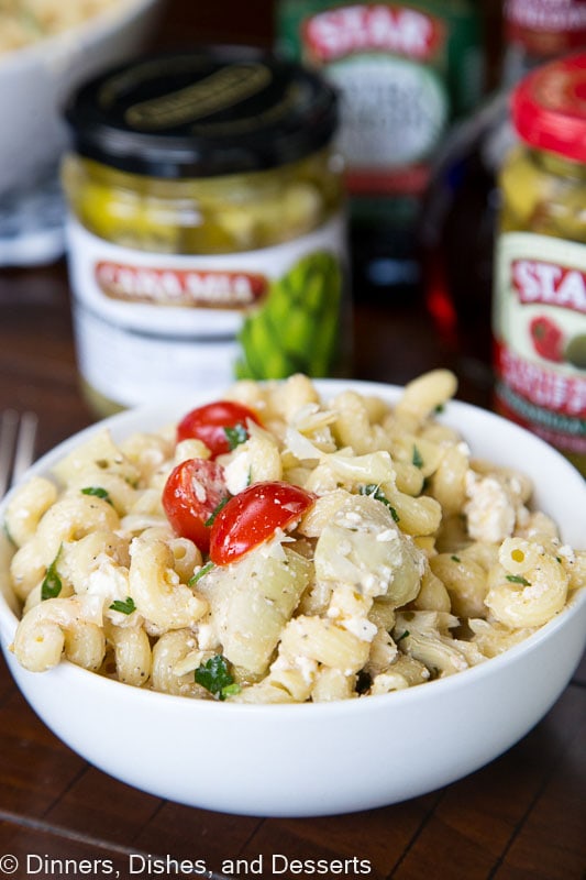 A close up of a pasta salad with tomatoes and artichokes