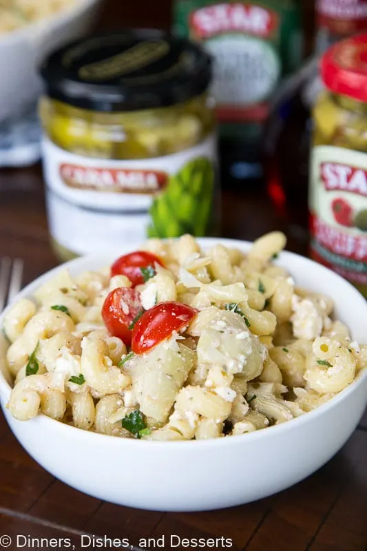 A close up of a pasta salad with tomatoes and artichokes
