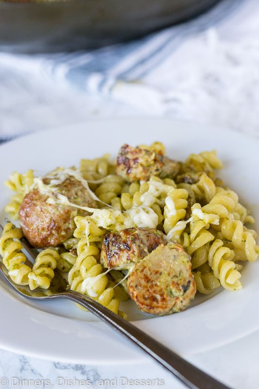 A plate of pesto pasta with meatballs