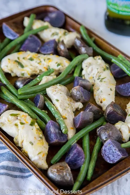 chicken, green beans and purple potatoes on a baking tra
