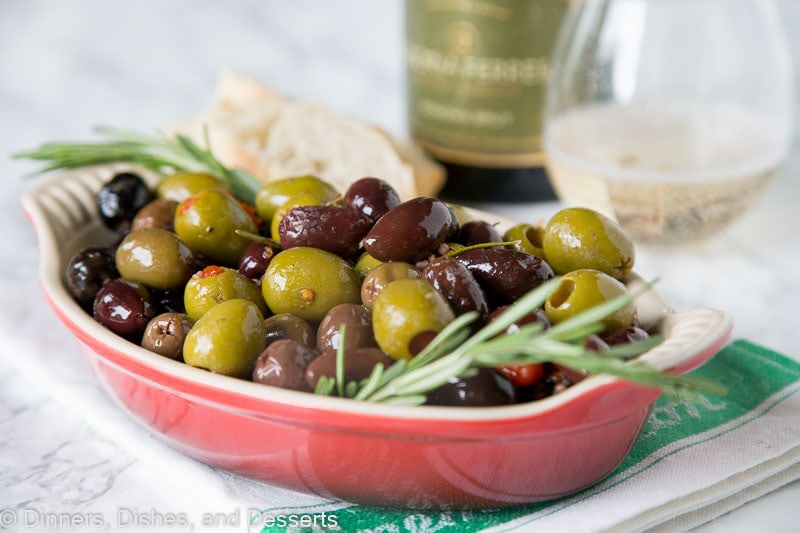 bowl of roasted olives with a sprig of rosemary