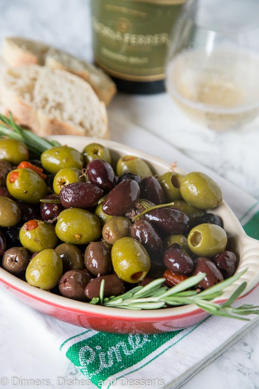 bowl of roasted olives with a sprig of rosemary
