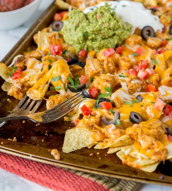 Sheet Pan Chicken Nachos - make a full tray of nachos for the whole family in minutes. Customize it to what your family likes, and get a dinner on the table, your family will love super fast!