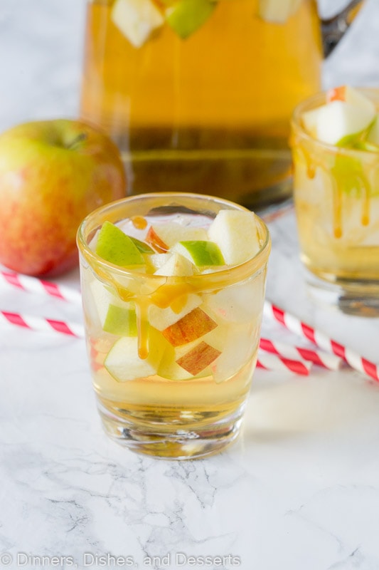 apple sangria in a glass with red and white straws