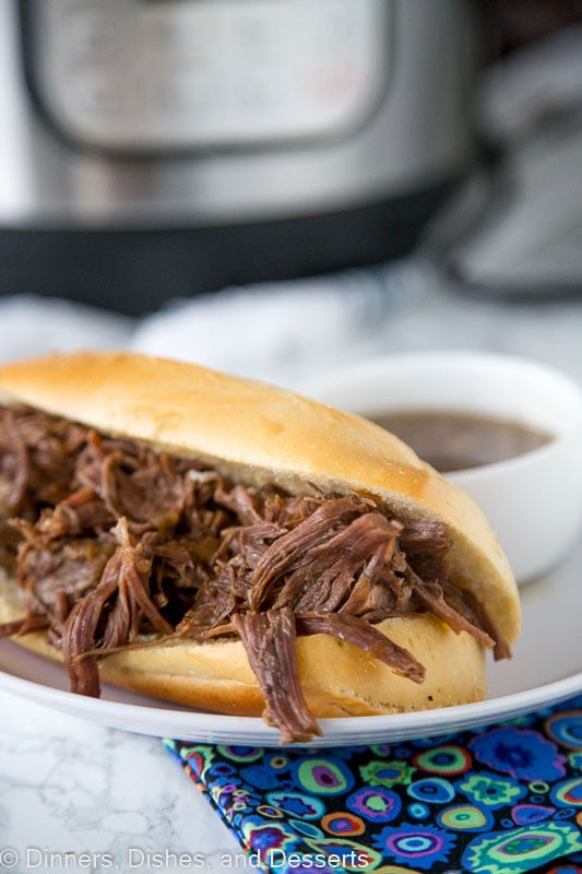 A plate with a sandwich of French dip and Slow cooker