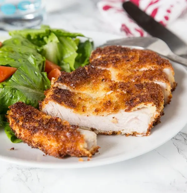 Crispy Pork Cutlet - tender boneless pork chops breaded and pan fried to crispy perfection. Served with a salad for a delicious meal any night of the week.