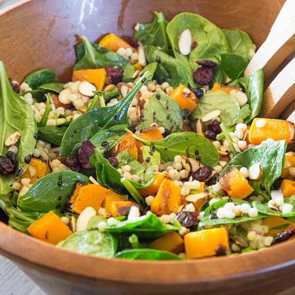 Fall Couscous Salad - Israeli couscous, spinach, butternut squash. cranberries and pecans all tossed with a balsamic vinaigrette. Great fall salad for the holidays, potlucks, or just because.