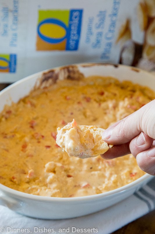 shrimp dip on a table with a cracker scoop of dip