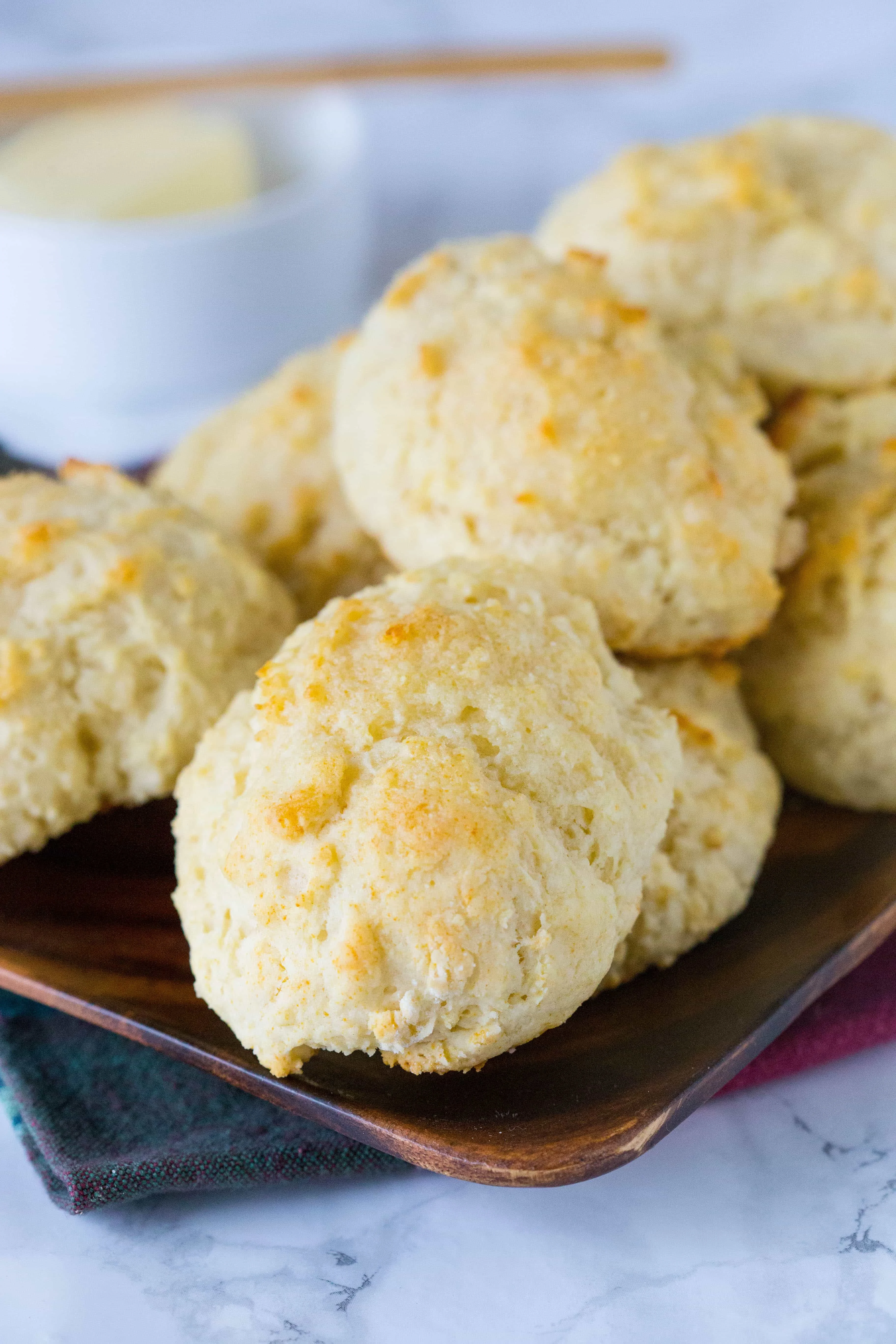 A wooden serving tray full of biscuits. 