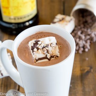 A cup of spiked hot chocolate on a table with marshmallows