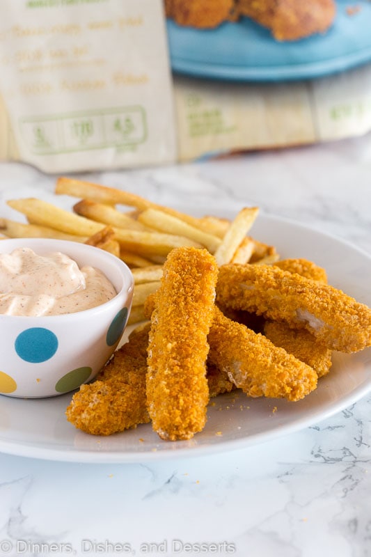 fish sticks on a plate with dipping sauce