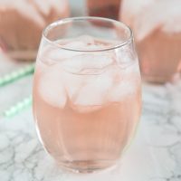A close up of a wine glass with rose wine spritzer
