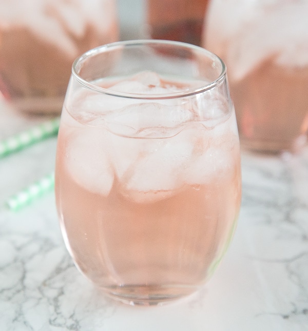 A close up of a wine glass with rose wine spritzer