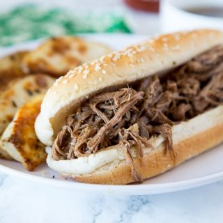 A close up of a french dip sandwich on a plate