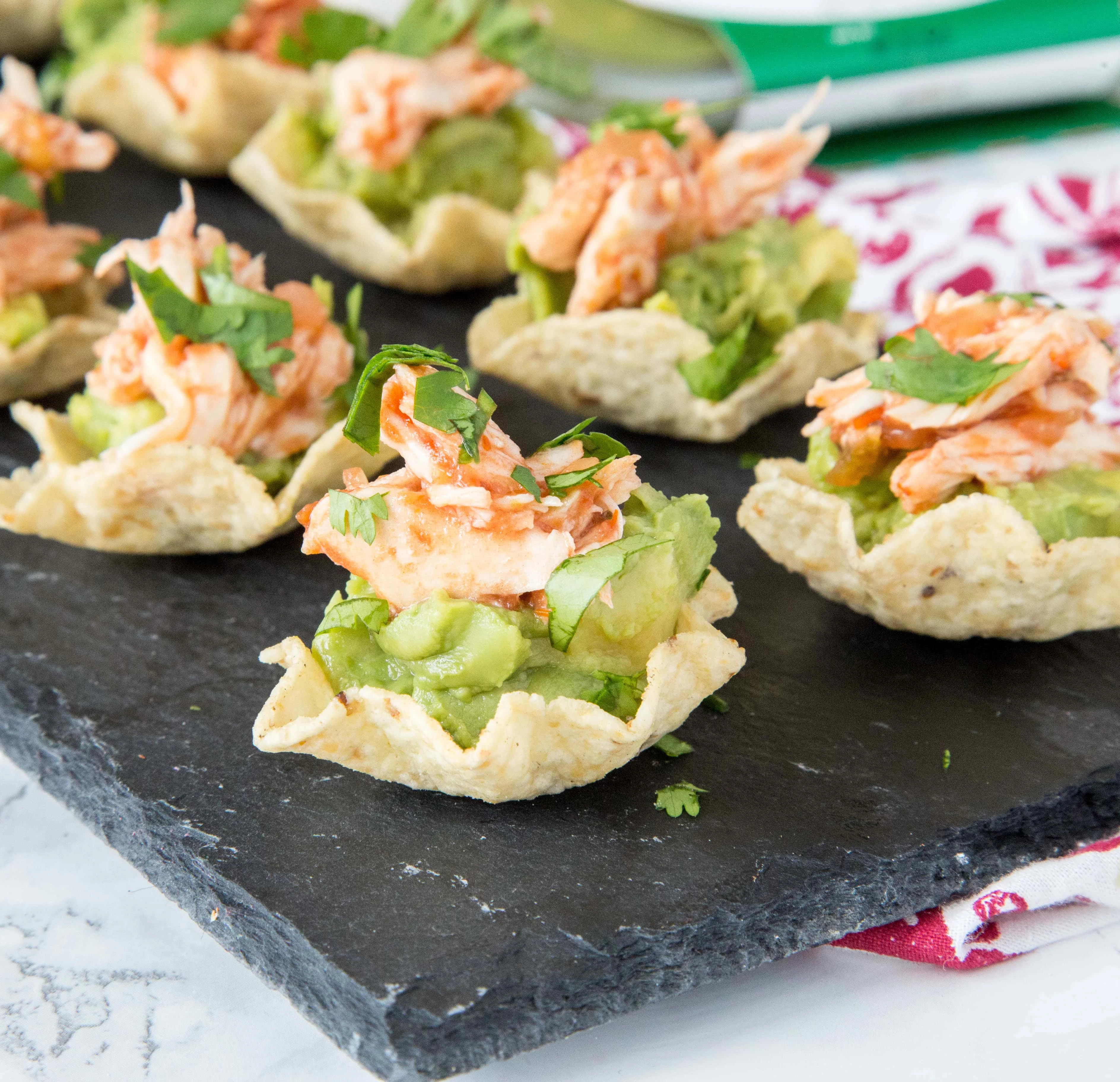 Guacamole Chicken Bites - Need a fun chicken appetizer for a party or get together.  These are filled with delicious guacamole, spicy salsa chicken, and topped with cilantro.  Great for snacking or entertaining!  