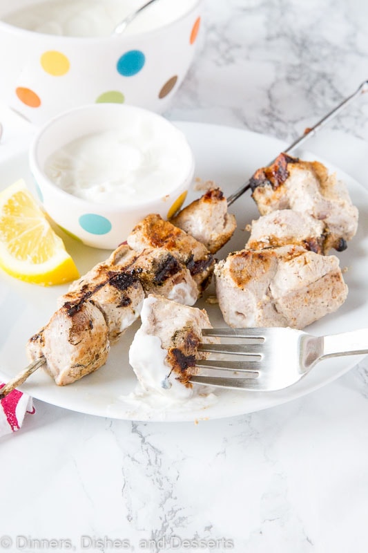 A plate of food with a fork, with pork kebabs