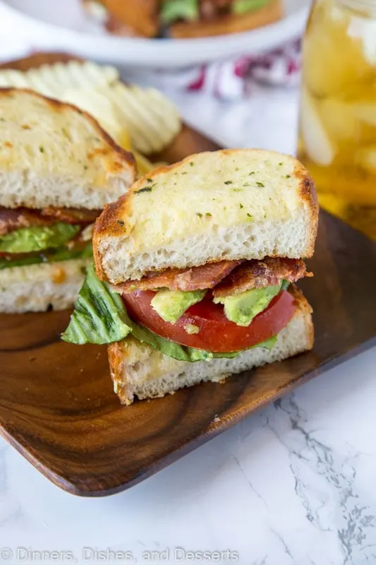 A sandwich cut in half on a plate, with Bread and BLT