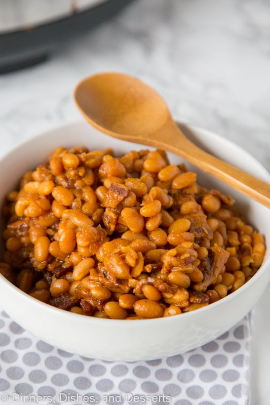 A bowl of food on a plate, with Bean and Baked beans