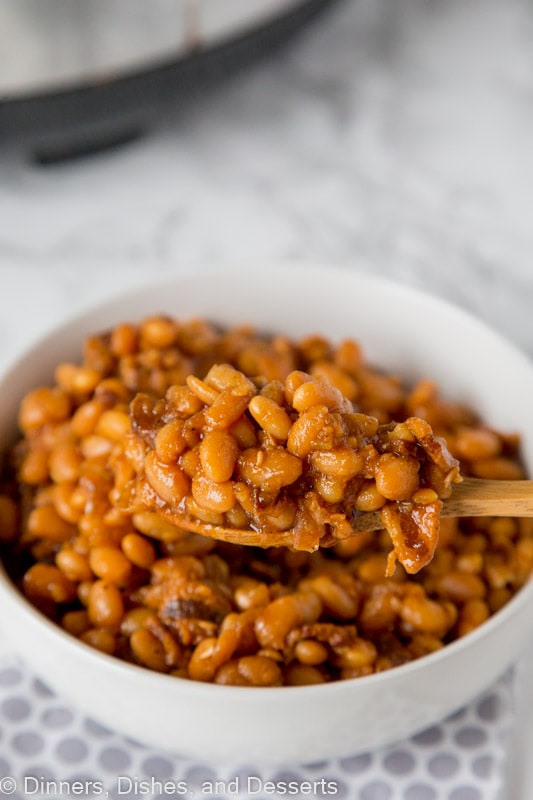 A bowl of food on a plate, with Bean and Baked beans