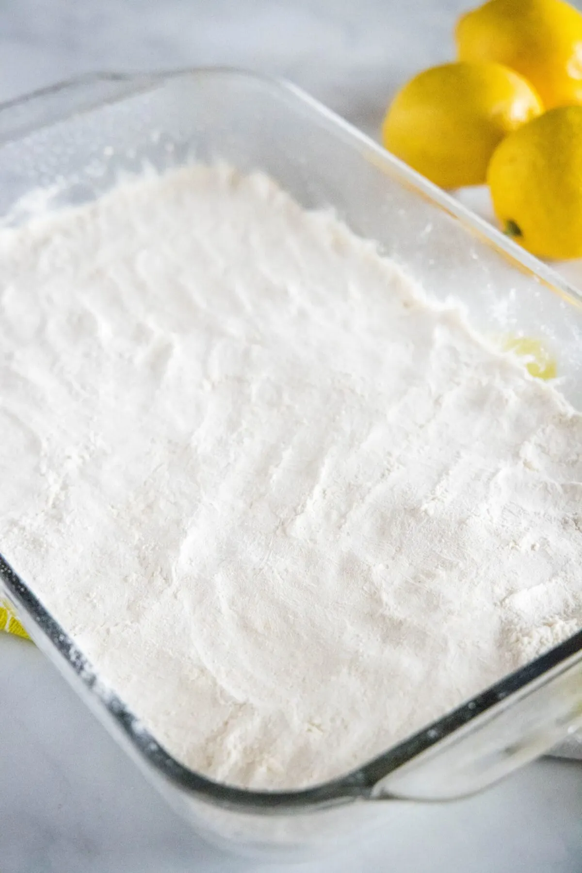 A baking pan filled with uncooked lemon bar dough