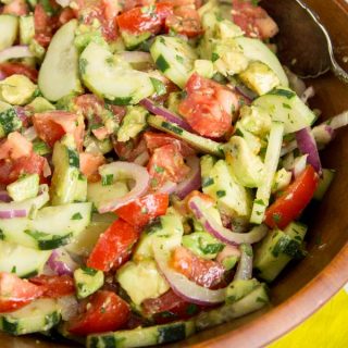 Cucumber Tomato Salad - Easy summer salads are the perfect side dish and great for potlucks. This cucumber salad is full of cucumbers, tomatoes, onions, and avocado tossed with a light vinaigrette dressing.