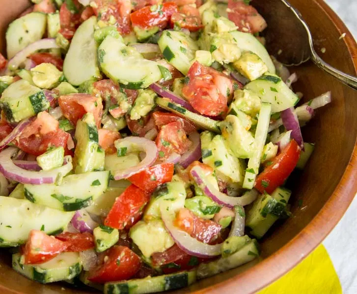 Cucumber Tomato Salad - Easy summer salads are the perfect side dish and great for potlucks. This cucumber salad is full of cucumbers, tomatoes, onions, and avocado tossed with a light vinaigrette dressing.