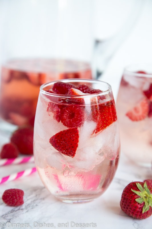 A close up of a glass cup on a table, with Sangria and Wine