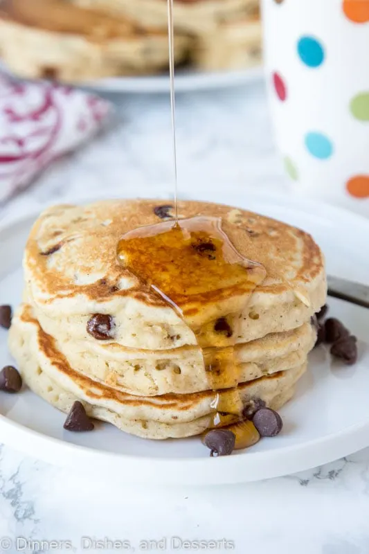 banana pancakes with chocolate chips stacked on a plate with syrup
