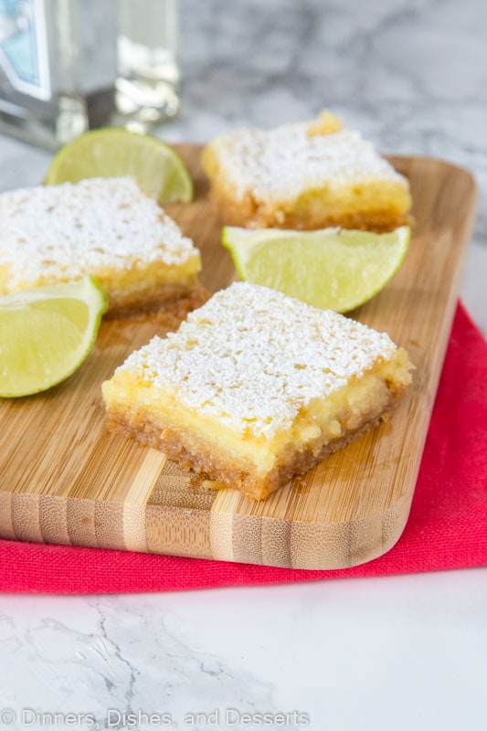 sliced margarita bars on a cutting board with lime wedges