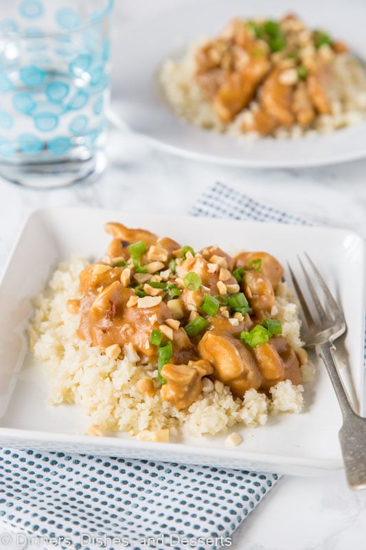 chicken satay stir fry over rice on a plate topped with peanuts